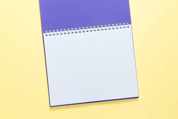 Vista dall'alto di notebook aperto su sfondo giallo, blocco note ufficio piatto lay — Foto Stock