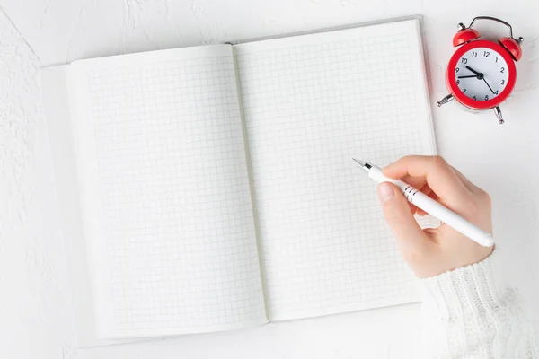 Cuaderno con hoja vacía sobre fondo blanco con pluma en las manos — Foto de Stock