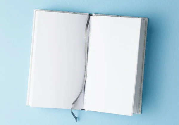 Open notebook on blue table top view, with blank page — Stock Photo, Image