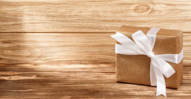 Ahşap arkaplan görünümlü kurdeleli hediye kutusu. 