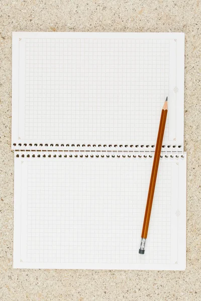 Открыть тетрадь с карандашом на столе — стоковое фото