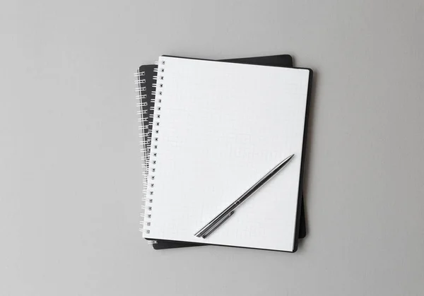 Draufsicht auf ein offenes schwarzes Notizbuch mit Stift auf grauem Hintergrund — Stockfoto