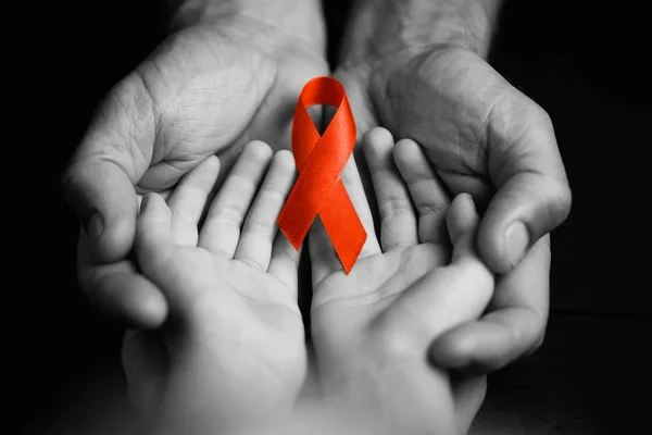 child with AID red ribbon on a dark background.black and white.