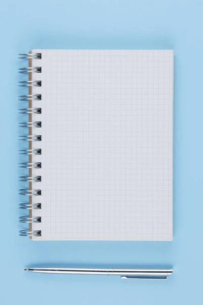 Školní zápisník s perem na modrém stolku horní pohled — Stock fotografie