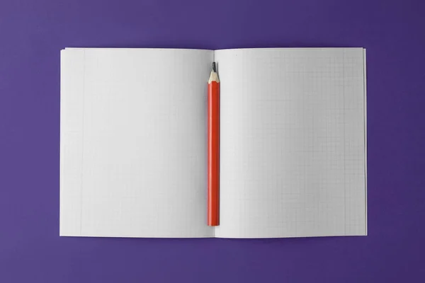 school notebook with pencil on the violet background