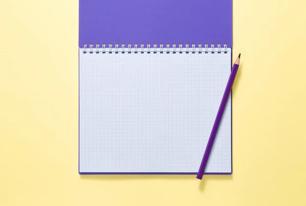 Top view of a open notebook with pencil on yellow background — Stock Photo, Image