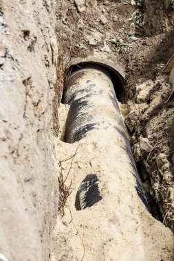 Yerin derinliklerinde bir kanalizasyon borusunun değiştirilmesi.