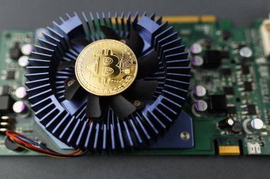 ekran kartında bitcoin, bilgisayar kartının yanındaki masada bitcoin sikkesi