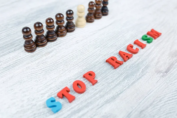 No to racism in colored letters on a gray wooden background
