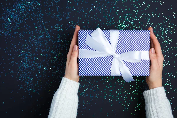 Gift on the hands, flat lay on a starry background — Stock Photo, Image