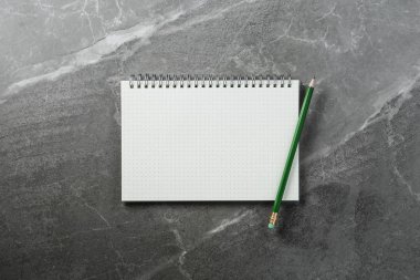mermer arka plan üzerinde yeşil kalem ile defter, üst görünüm