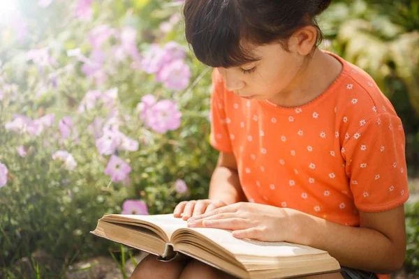 可爱的女孩在阳光明媚的日子，国际扫盲日户外阅读. — 图库照片