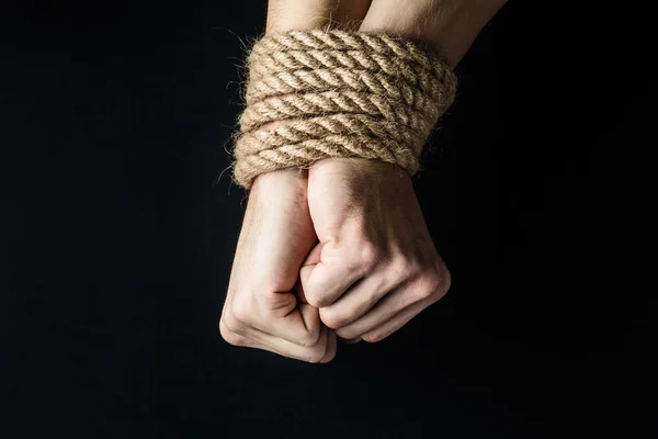 Siyah arka planda halatla bağlanmış eller