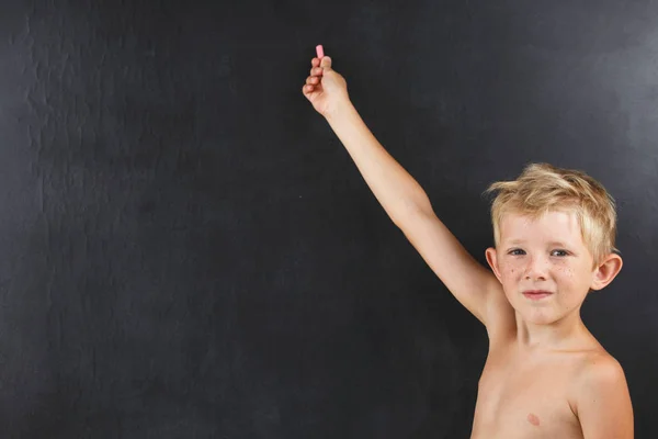 Kleine jongen zonder een t-shirt punten op een leeg bord — Stockfoto