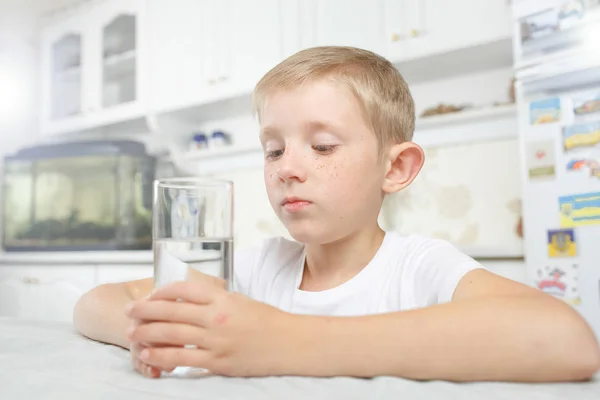 Niño en la cocina con un vaso de agua limpia — Foto de Stock
