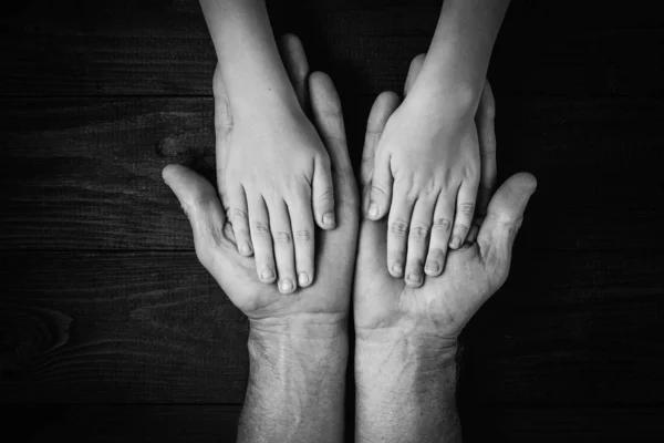 Mãos adultas segurando as mãos da criança, Family Help Care Concept.black e branco . — Fotografia de Stock