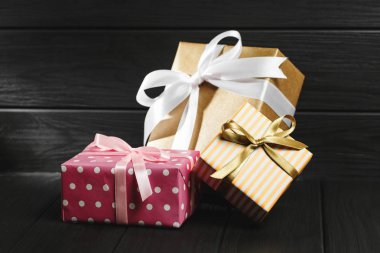 Siyah ahşap arka plan üst görünümünde kurdele ile hediye kutusu.