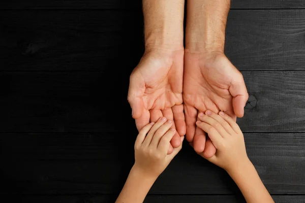 Erwachsene Hände halten Kinderhände, Familienhilfekonzept — Stockfoto