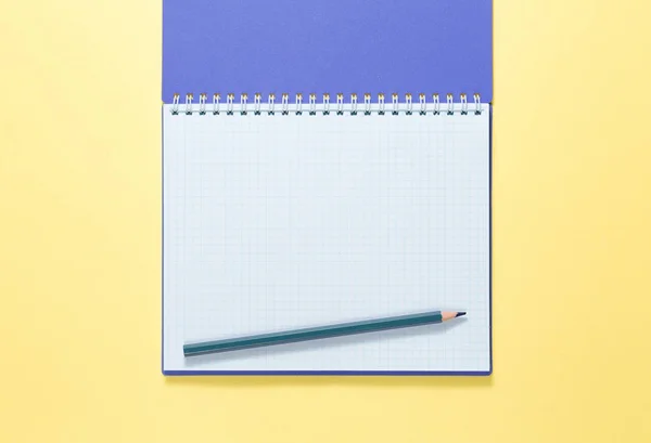 Top view of a open notebook with pencil on yellow background — Stock Photo, Image