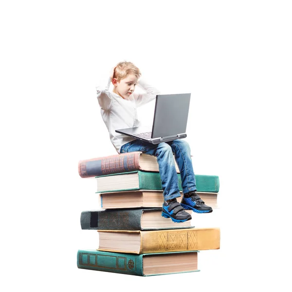 Jongen zitten op boeken met laptop geïsoleerd op witte achtergrond — Stockfoto