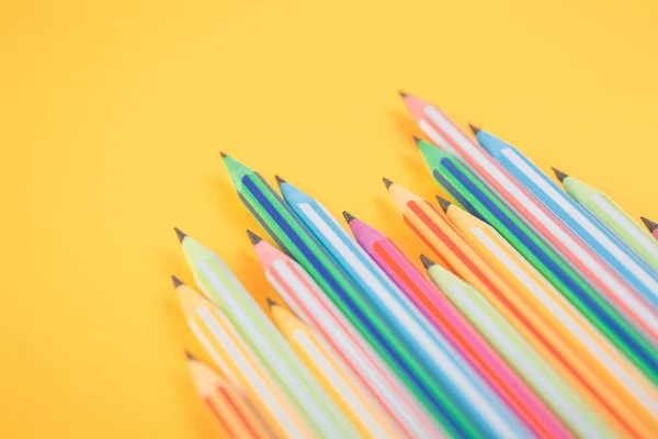 Разноцветные карандаши на желтом изолированном фоне — стоковое фото