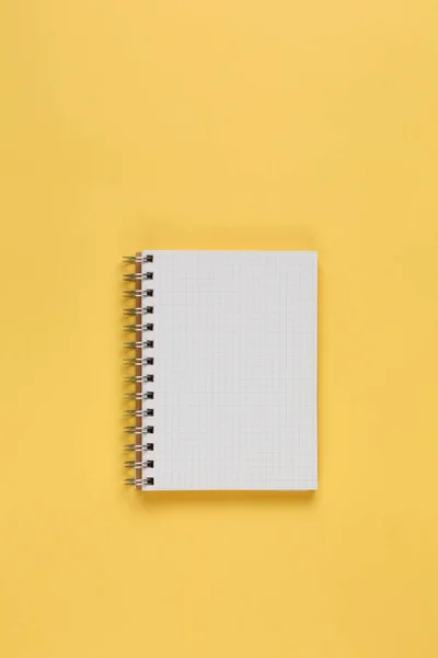 Notebook na žlutém pozadí horní pohled — Stock fotografie