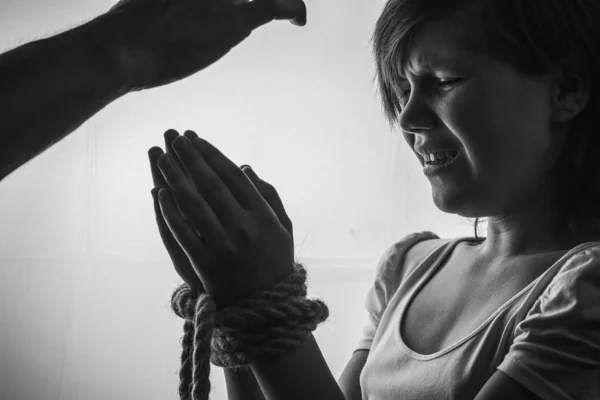 Little girl with bound hands cries at her hand, violence against children.black and white. — 스톡 사진