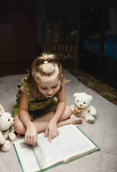 Hermosa niña leer libro con su juguete favorito —  Fotos de Stock