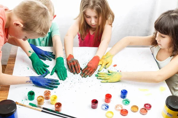 Niños pintan con las manos sobre la mesa — Foto de Stock
