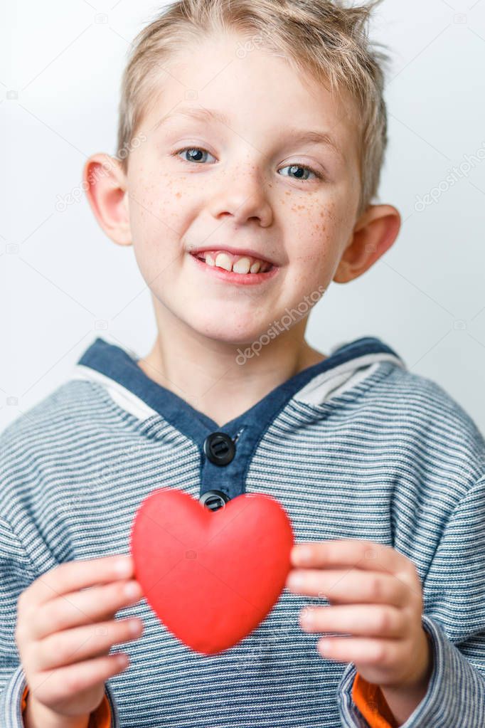 child holds a heart in his hands