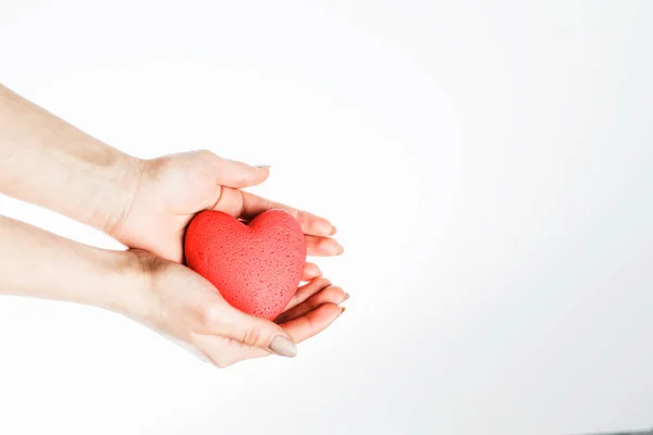 Avuçlarında kırmızı bir kalple kadın eli