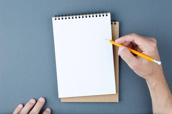 Cuaderno de la página clara y manos masculinas con lápiz. — Foto de Stock