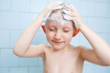 Küçük çocuk duşta yıkanıyor.