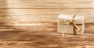 Tahta arka planda kurdeleli hediye kutusu