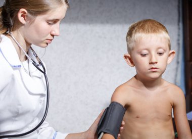 Beyaz önlüklü, çocuklu kadın doktor.