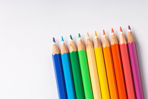 colored pencils in row on a white background