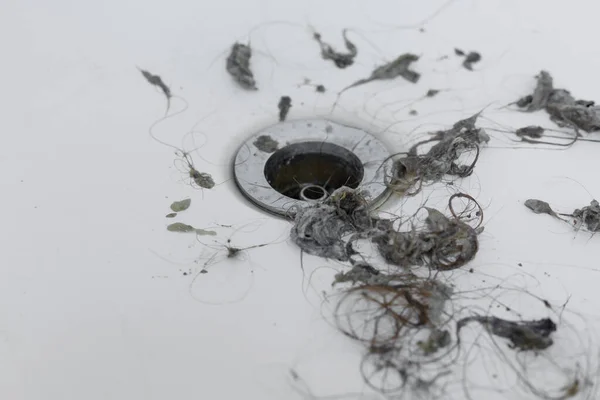 Kanalizasyon deliğine yakın toprak ve saç temizleme