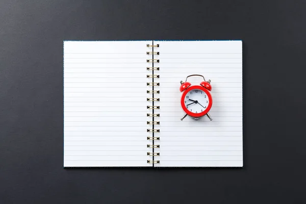 Notebook aperto con sveglia rossa — Foto Stock