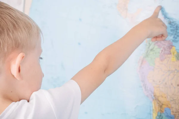 Kleine jongen op de achtergrond van een wereldkaart — Stockfoto