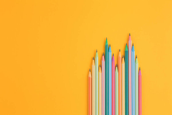 разноцветные карандаши на желтом изолированном фоне