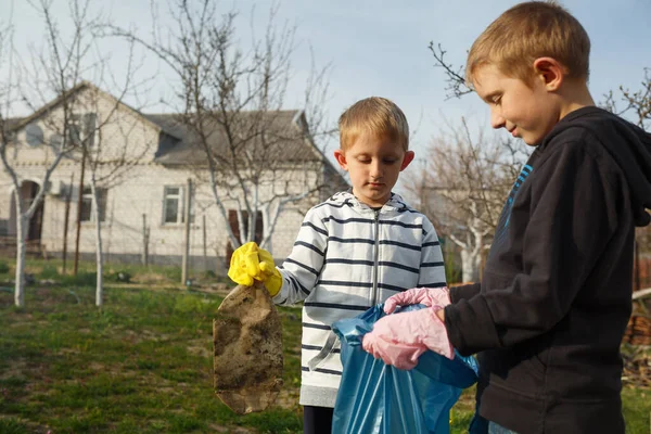 Zwei kleine Jungen im Park sammeln Plastikflaschen — Stockfoto