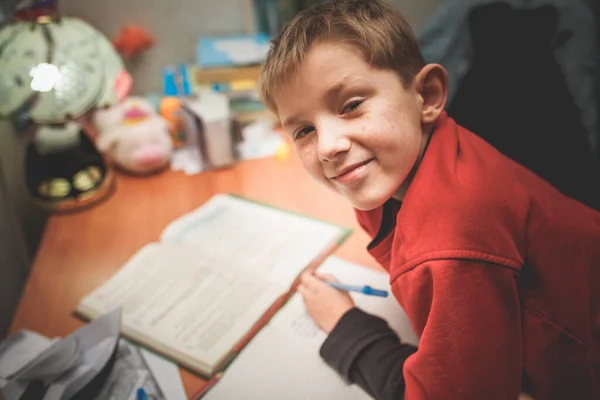 Dziecko odrabiające pracę domową w świetle lampy — Zdjęcie stockowe