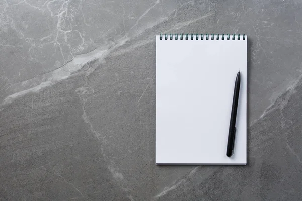 Cuaderno con pluma negra sobre fondo de mármol — Foto de Stock