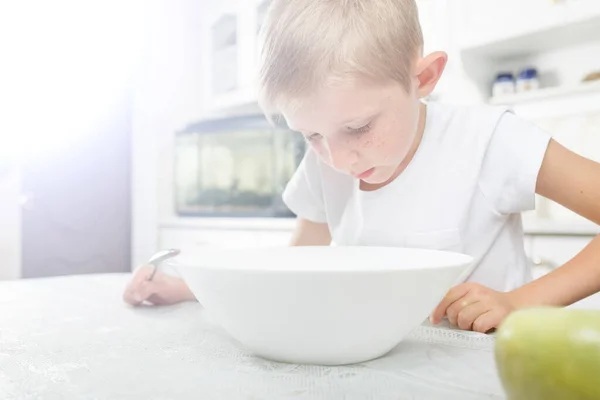 El niño desayuna en la mesa — Foto de Stock