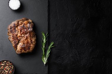 Siyah tabakta kızarmış biftek ve baharat.