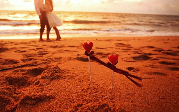 Red hearts background loving young couple hugging and kissing on the beach. happy love.