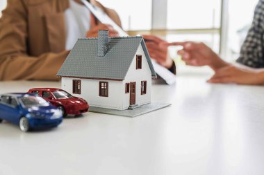 Emlakçı ve müşteriyle ev modeli C için tartışıyor