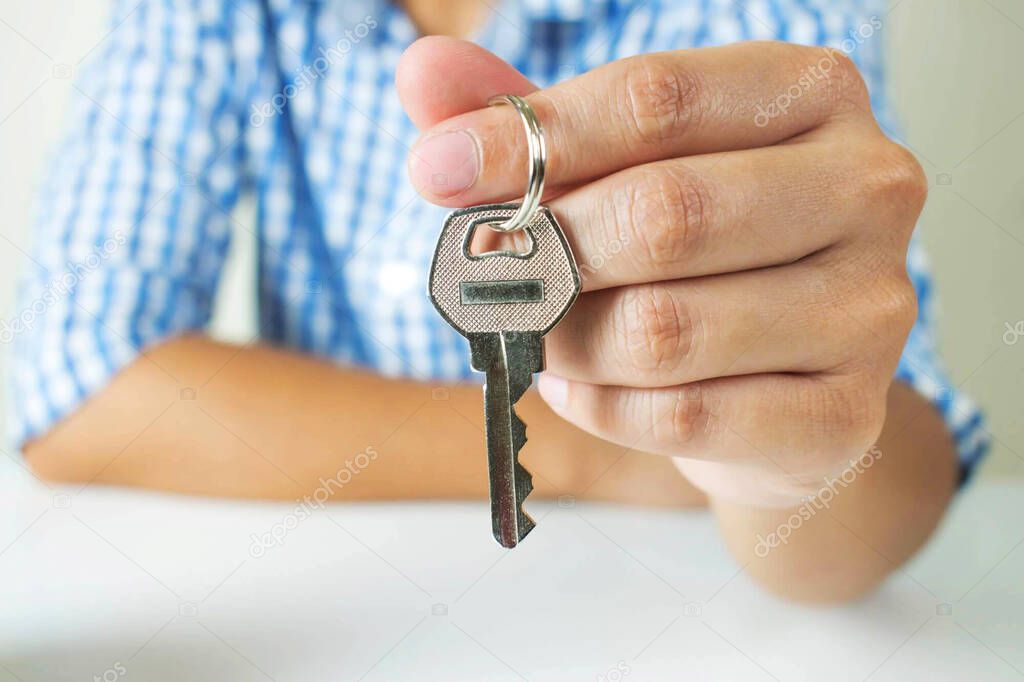 Asian people wear plaid shirts with keys in their hands. real estate business 