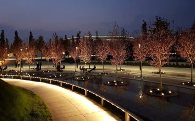 İnsanlar akşam parkında dinleniyor.