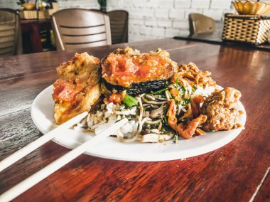 Biraz ara ver. Vejetaryen yemekleri herkes için lezzetli olabilir. Kızarmış soya eti, pilav ve güveçte sebzeler, Asya 'nın basit vejetaryen kafesinde yemek çubuklarıyla birlikte. Sağlıklı beslenme, hayvanlarla ilgilenme.